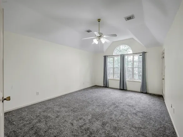 an empty room with chandelier fan and closet area