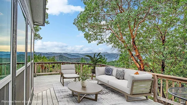 a view of roof deck with couches and wooden floor