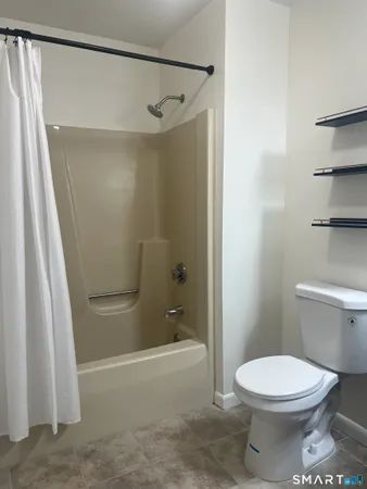a bathroom with a toilet and a shower