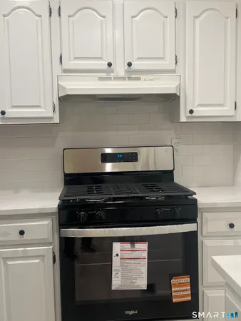 a kitchen with white cabinets and black appliances