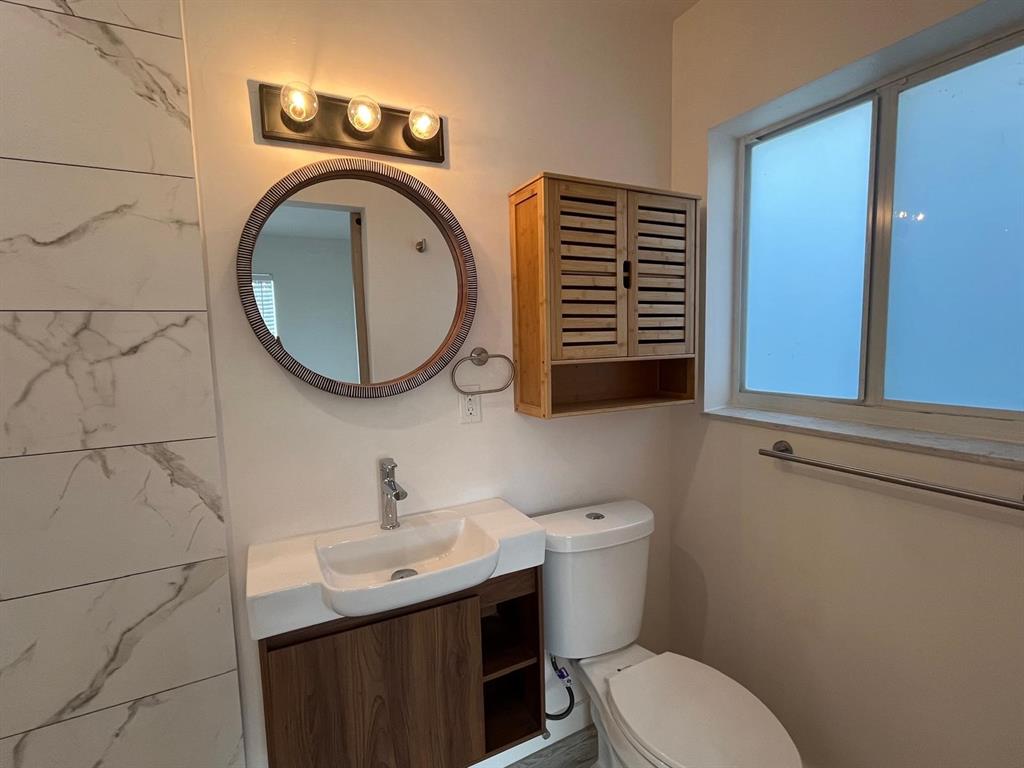 1712 Fletcher Street, Unit 5 Hollywood, FL 33020 - Photo 6 of 11 a bathroom with a toilet a sink and a mirror