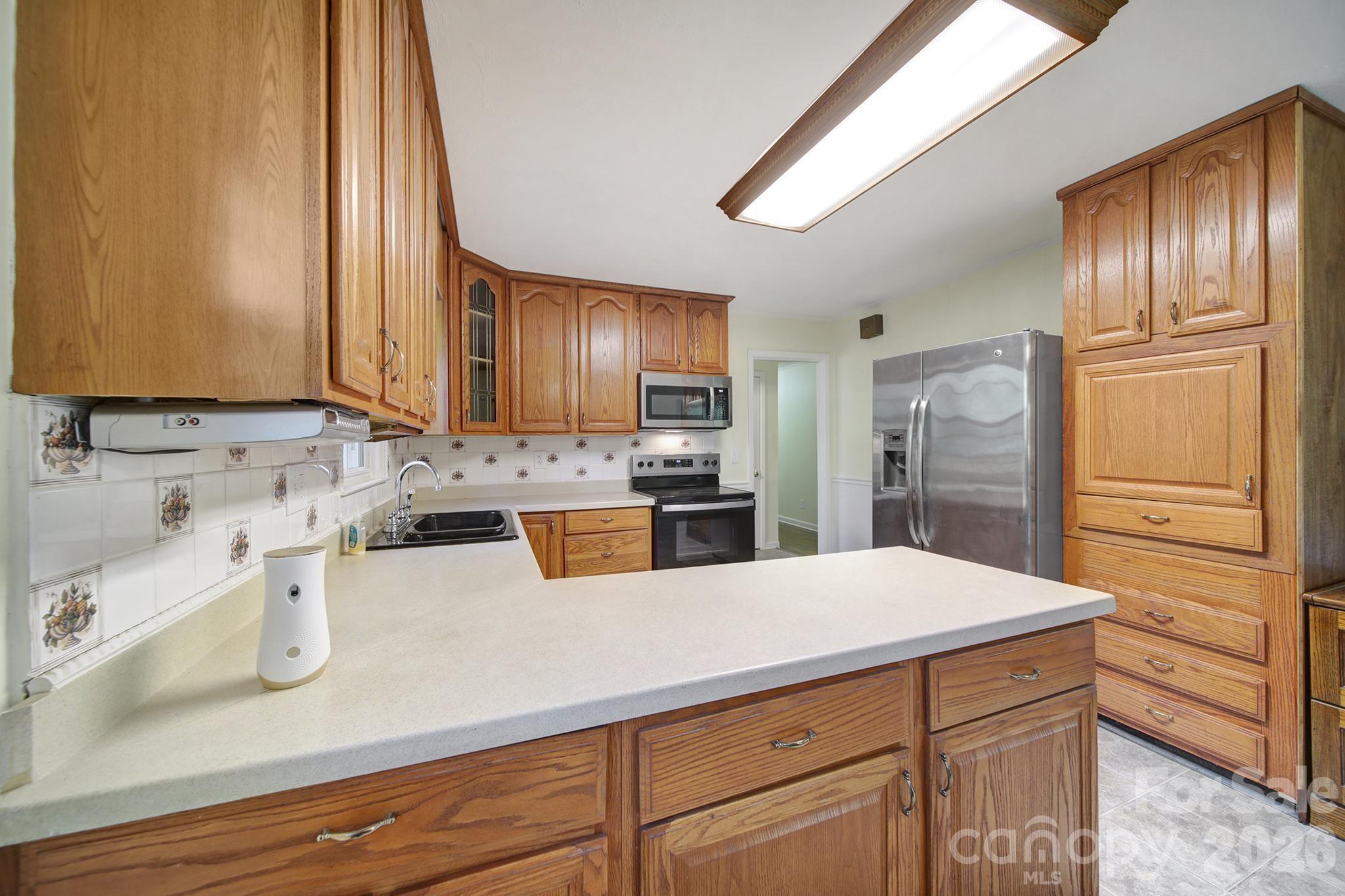 3987 Taxahaw Road Lancaster, SC 29720 - Photo 16 of 28 a kitchen with stainless steel appliances a refrigerator sink and cabinets