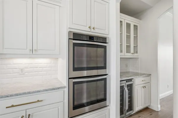 a kitchen with granite countertop white cabinets and stainless steel appliances