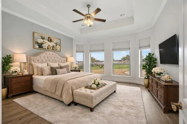 a bedroom with a bed a couch and a flat screen tv