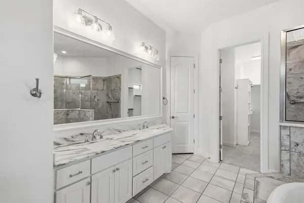 a spacious bathroom with a granite countertop sink mirror and shower