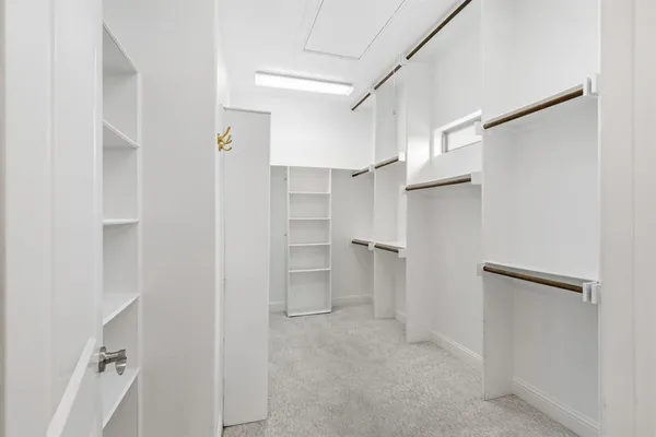 a view of walk in closet with white walls