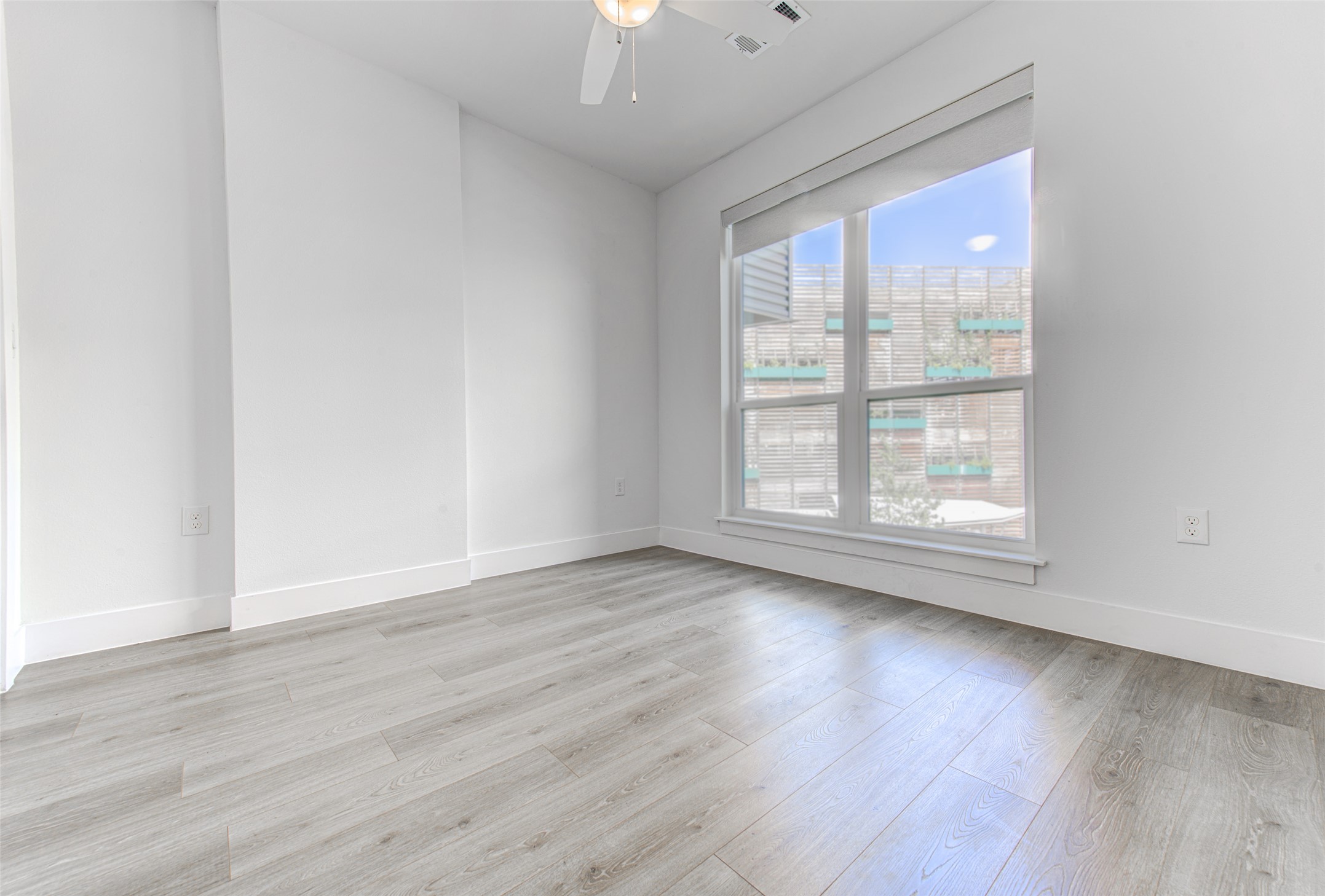 1701 Simond Avenue, Unit 229 Austin, TX 78723 - Photo 11 of 20 an empty room with wooden floor and windows