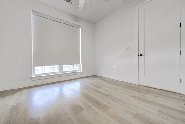 a view of wooden floor and window in a room