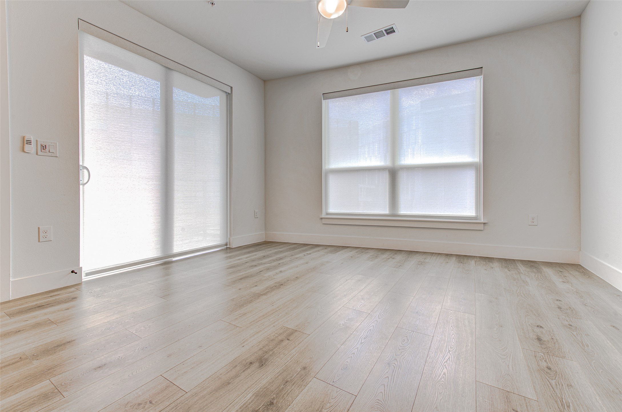 1701 Simond Avenue, Unit 229 Austin, TX 78723 - Photo 6 of 20 an empty room with wooden floor and windows