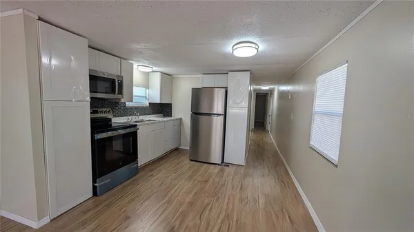 a kitchen with stainless steel appliances a refrigerator and a stove top oven