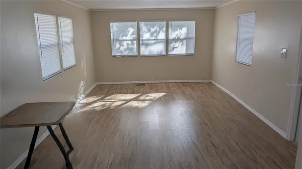 a view of a room with wooden floor and windows