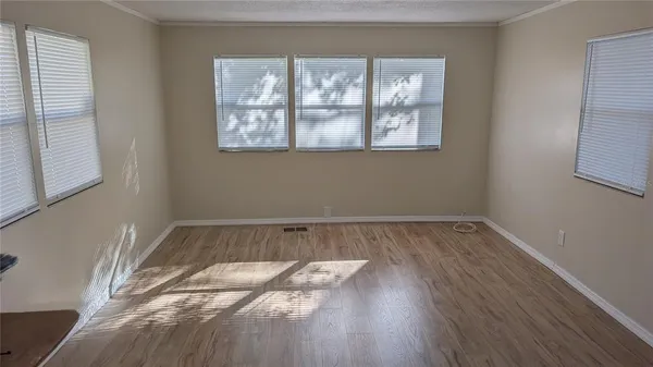a view of a room with wooden floor and window