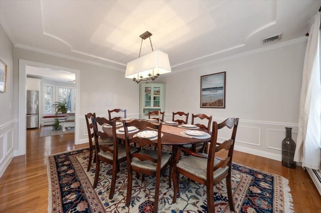 125 Maple Street Scituate, MA 02066 - Photo 13 of 42 a view of a dining room and livingroom with furniture wooden floor a rug a painting and a chandelier