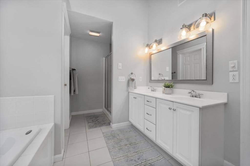 125 Maple Street Scituate, MA 02066 - Photo 21 of 42 a spacious bathroom with a double vanity sink a mirror and a bathtub