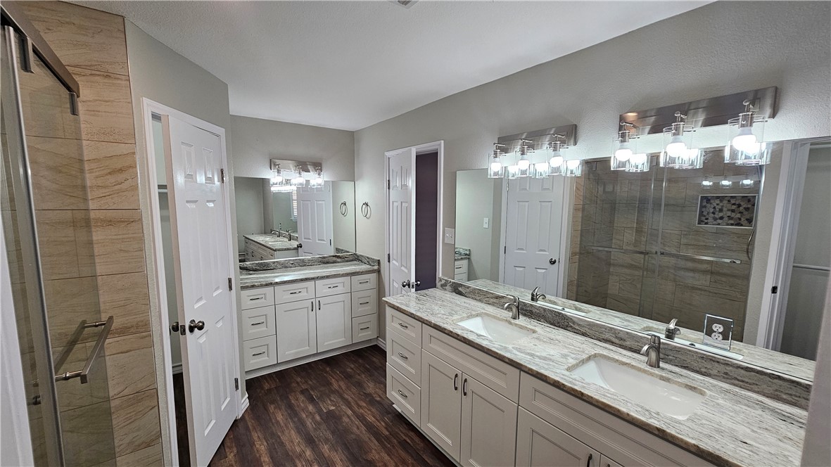 2438 Scotch Moss Drive Corpus Christi, TX 78414 - Photo 22 of 34 a bathroom with a double vanity sink and mirror with shower