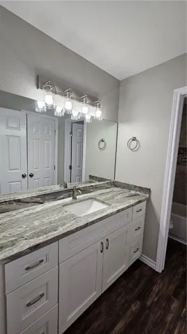 a bathroom with a granite countertop sink and a mirror