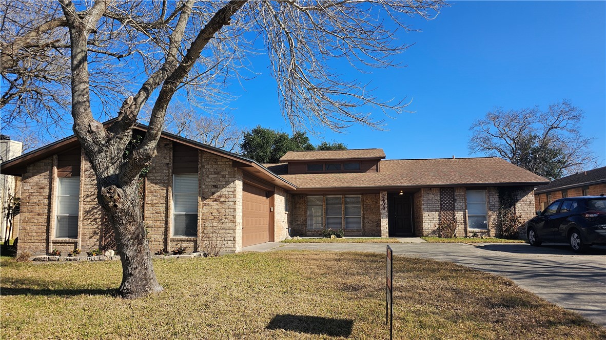 2438 Scotch Moss Drive Corpus Christi, TX 78414 - Photo 3 of 34 a view of a white house with large windows and a tree