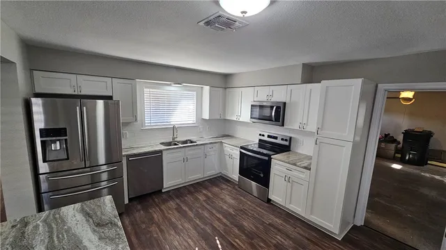 a kitchen with granite countertop stainless steel appliances and wooden cabinets