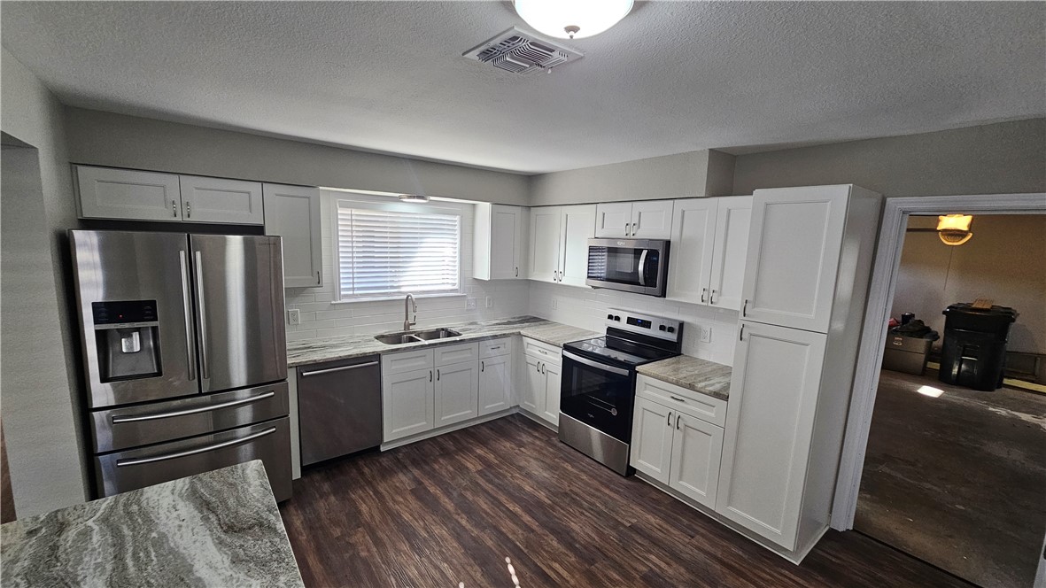 2438 Scotch Moss Drive Corpus Christi, TX 78414 - Photo 9 of 34 a kitchen with granite countertop stainless steel appliances and wooden cabinets