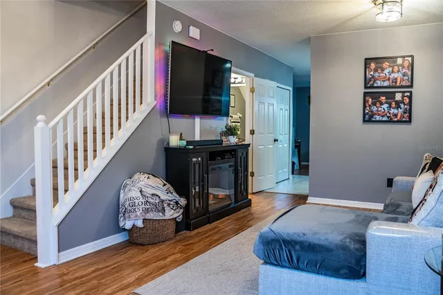 a kitchen with a refrigerator a stove top oven a sink dishwasher and white cabinets with wooden floor