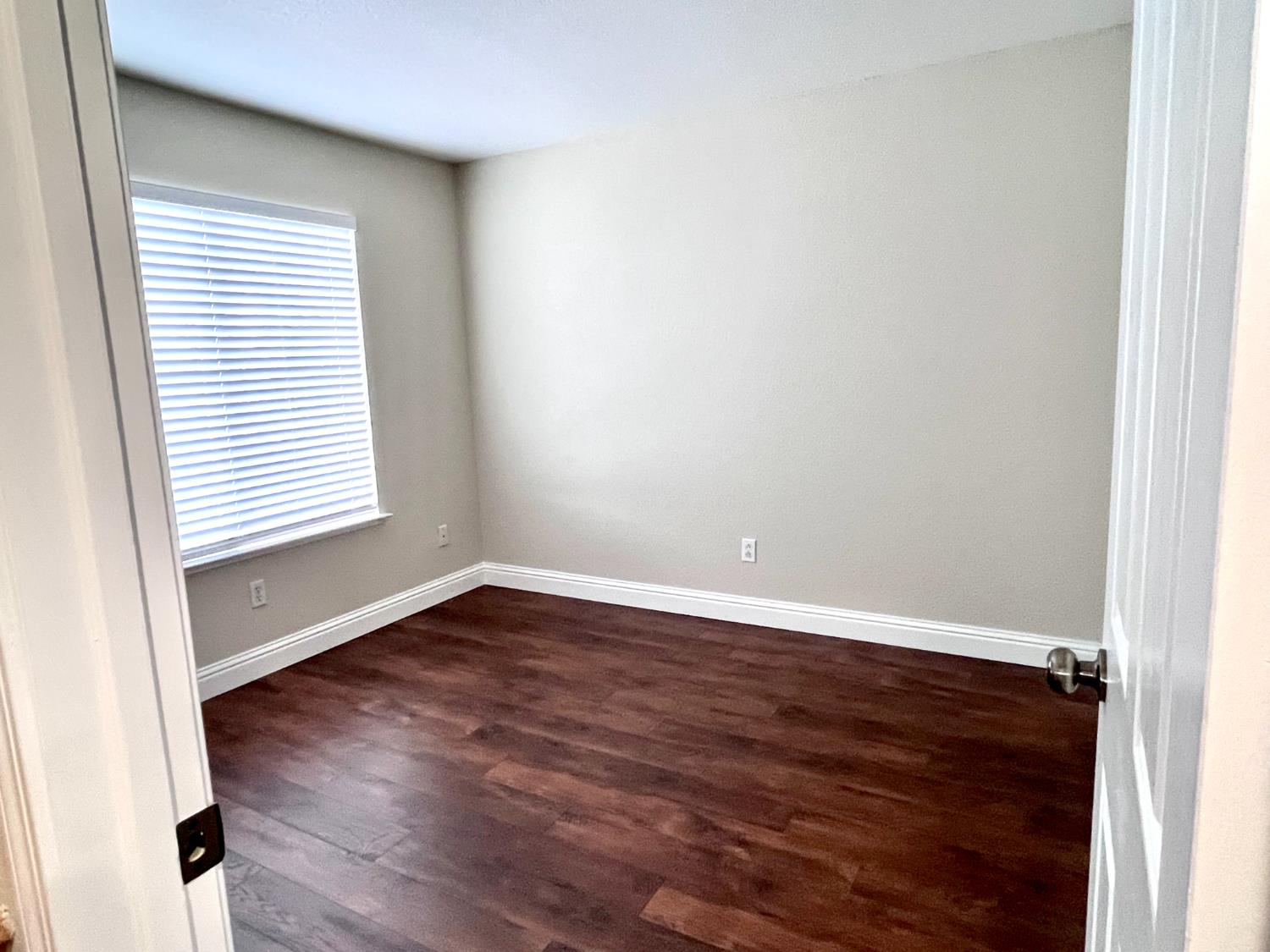13310 Parkhaven Street Lathrop, CA 95330 - Photo 24 of 27 an empty room with wooden floor and windows