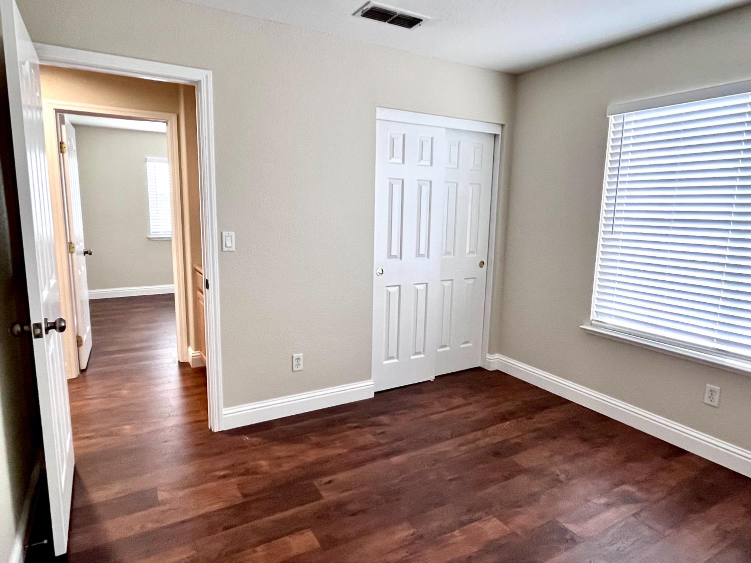 13310 Parkhaven Street Lathrop, CA 95330 - Photo 25 of 27 an empty room with wooden floor and windows