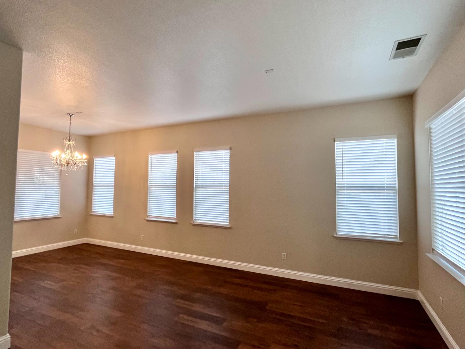 13310 Parkhaven Street Lathrop, CA 95330 - Photo 4 of 27 an empty room with wooden floor and windows