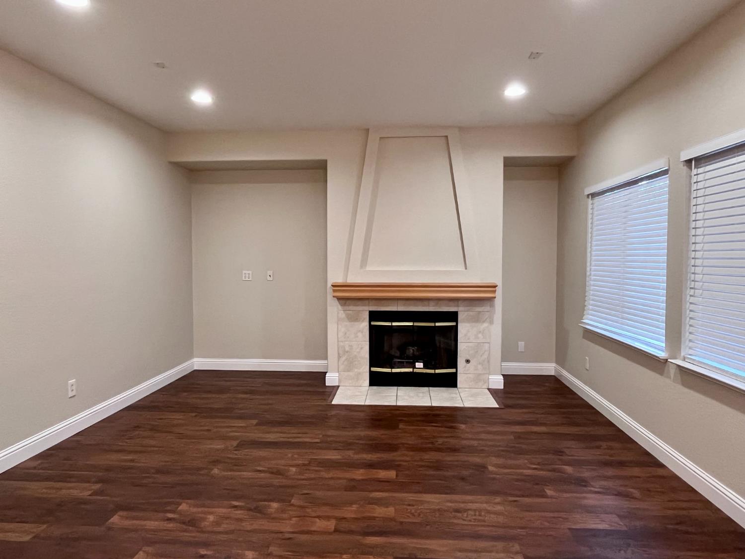 13310 Parkhaven Street Lathrop, CA 95330 - Photo 7 of 27 a view of an empty room with wooden floor fireplace and a window