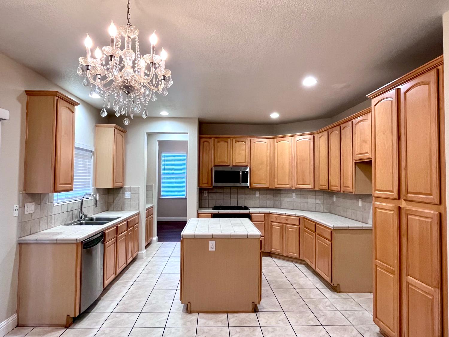 13310 Parkhaven Street Lathrop, CA 95330 - Photo 9 of 27 a kitchen with kitchen island granite countertop a sink counter top space appliances and cabinets
