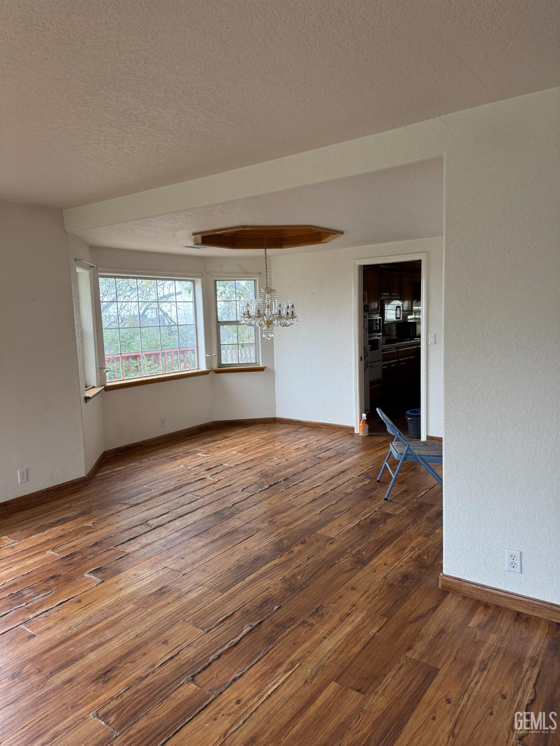 Undisclosed Address Tehachapi, CA 93561 - Photo 2 of 11 an empty room with wooden floor and windows