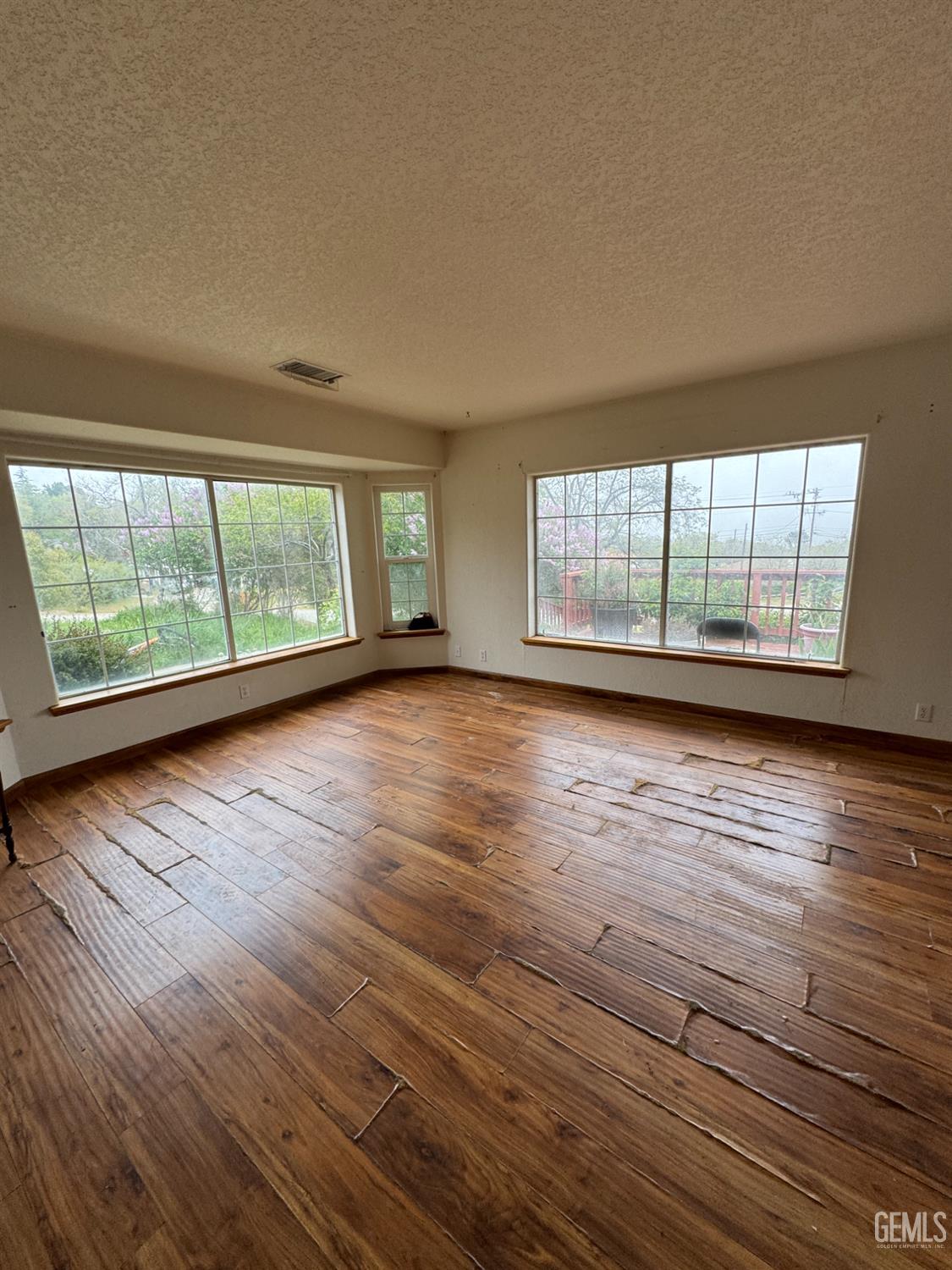 Undisclosed Address Tehachapi, CA 93561 - Photo 3 of 11 wooden floor in an empty room with a window
