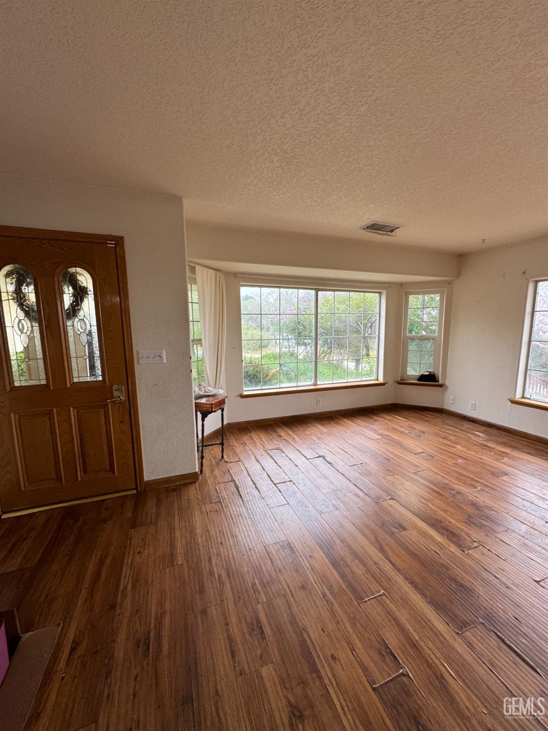 Undisclosed Address Tehachapi, CA 93561 - Photo 4 of 11 wooden floor in an empty room with a window