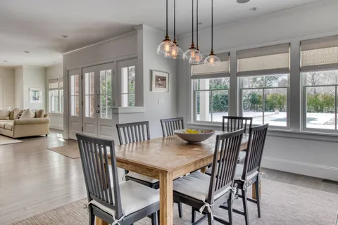 a view of a dining room with furniture large windows and wooden floor
