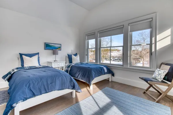 a bedroom with two beds and a large window