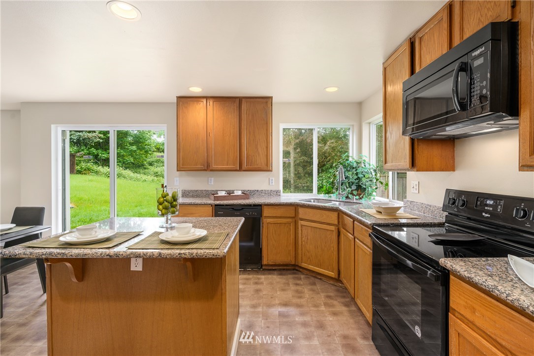 19104 113th Way Southeast Renton, WA 98055 - Photo 7 of 30 a kitchen with stainless steel appliances granite countertop a stove a sink and a microwave