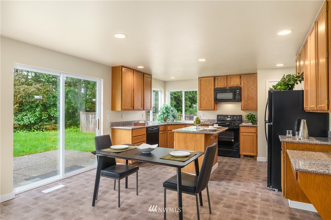 19104 113th Way Southeast Renton, WA 98055 - Photo 8 of 30 a kitchen with a table chairs refrigerator and microwave