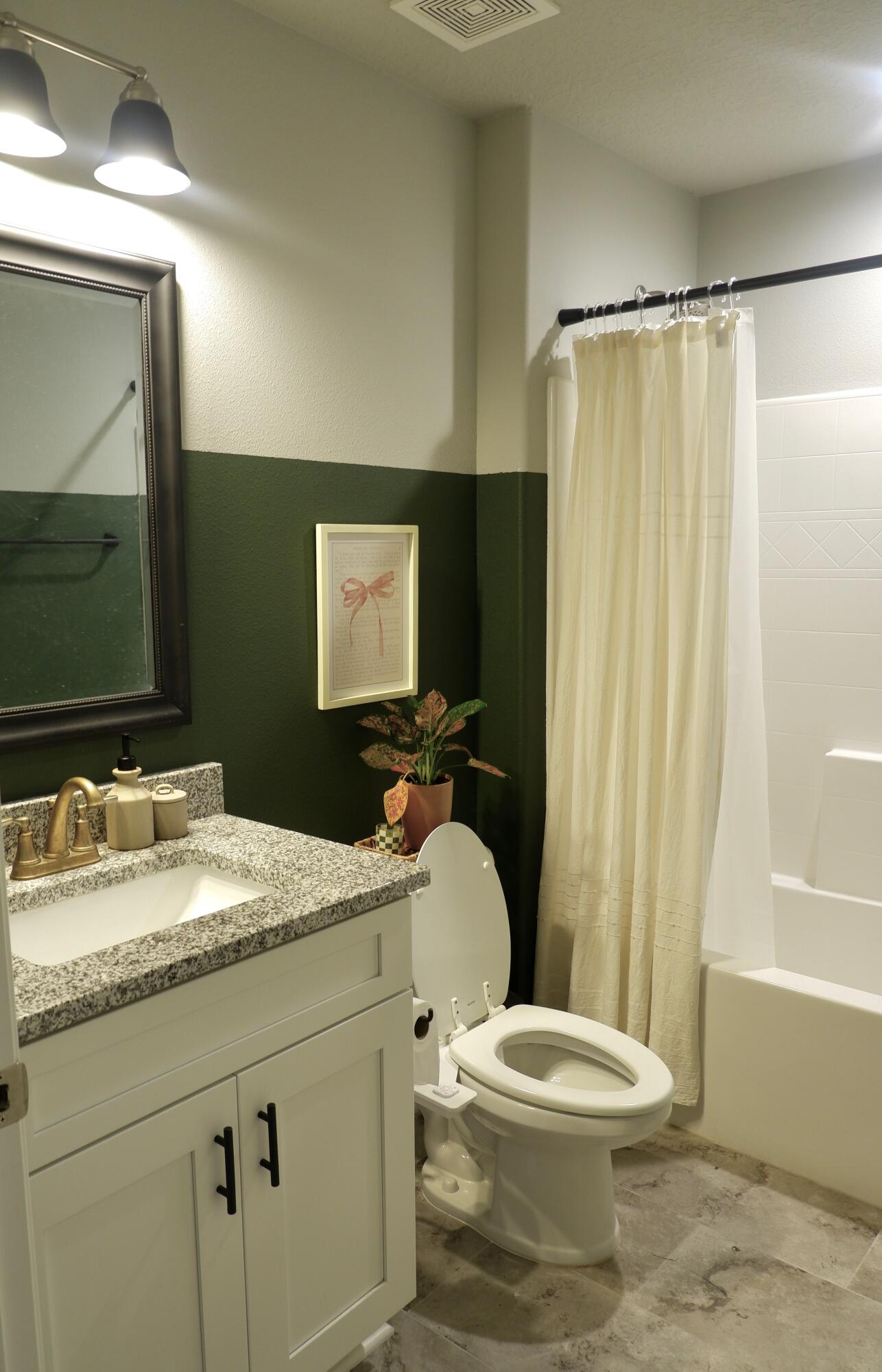 6841 Nelson Street Navarre, FL 32566 - Photo 13 of 14 a bathroom with a granite countertop toilet sink and mirror