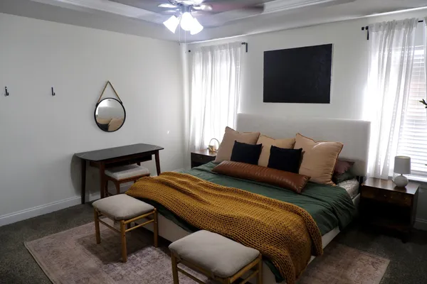 a bedroom with a bed a chair and a flat screen tv