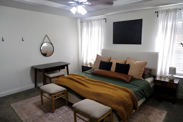 a bedroom with a bed a chair and a flat screen tv