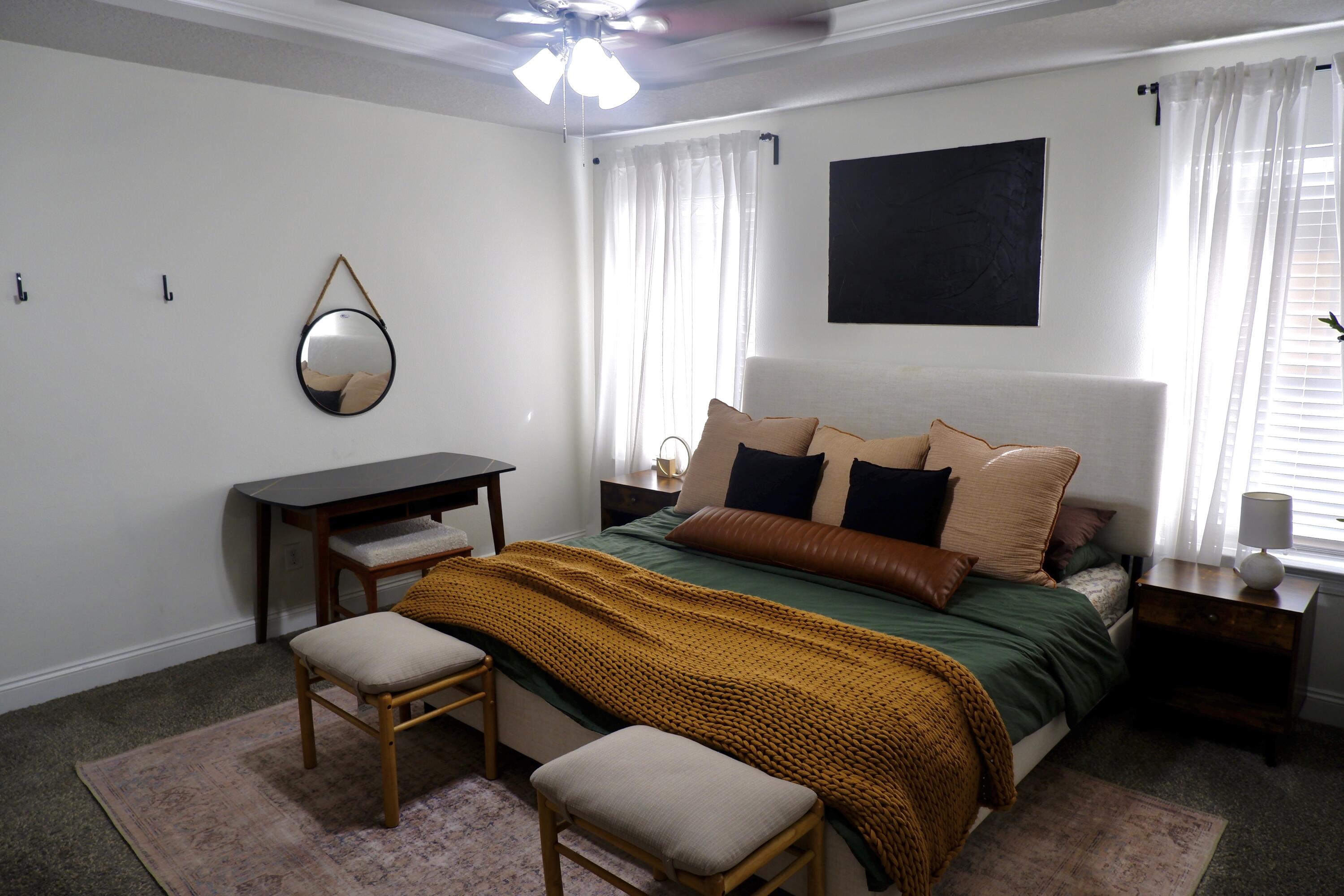 6841 Nelson Street Navarre, FL 32566 - Photo 8 of 14 a bedroom with a bed a chair and a flat screen tv