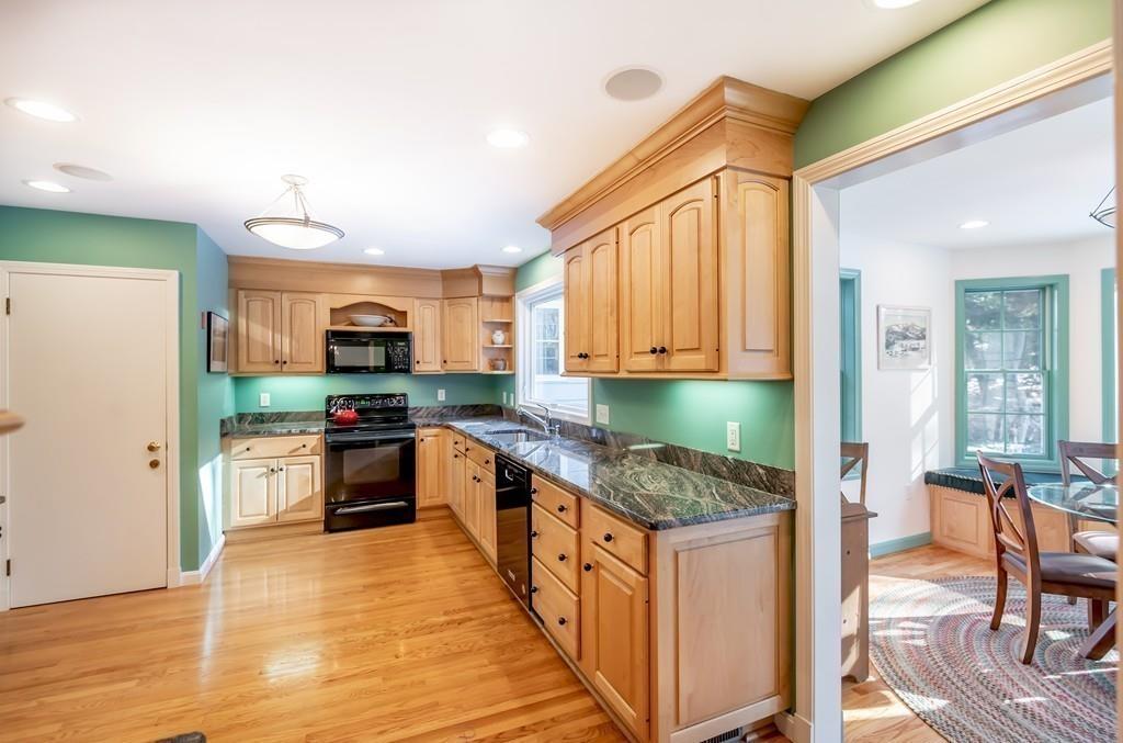 15 Arcadia Road Andover, MA 01810 - Photo 14 of 42 a kitchen with stainless steel appliances granite countertop a stove top oven a sink dishwasher a dining table and chairs with wooden floor