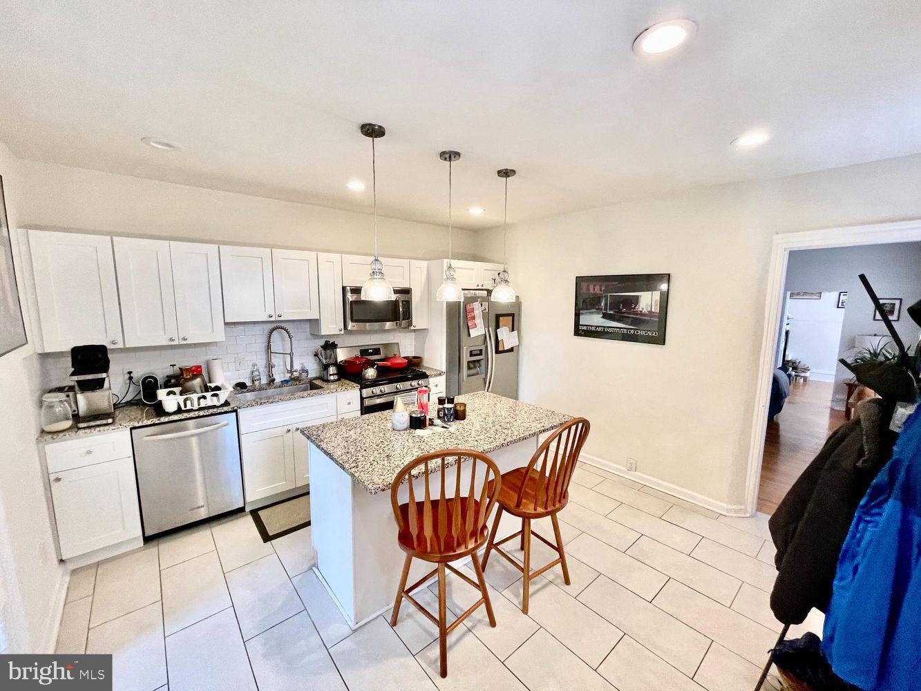 130 Green Lane, Unit 1 Philadelphia, PA 19127 - Photo 2 of 10 a kitchen with stainless steel appliances kitchen island granite countertop a sink a stove a refrigerator cabinets and chairs