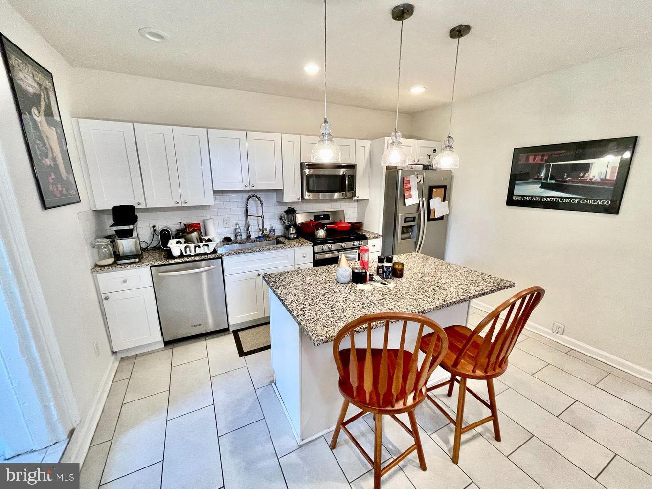 130 Green Lane, Unit 1 Philadelphia, PA 19127 - Photo 3 of 10 a kitchen with stainless steel appliances granite countertop a sink a stove a refrigerator a microwave oven with white cabinets and wooden floor