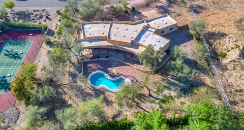 an aerial view of a house with a yard and large trees