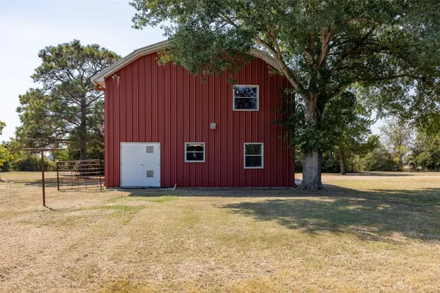 a view of a house with backyard and trees
