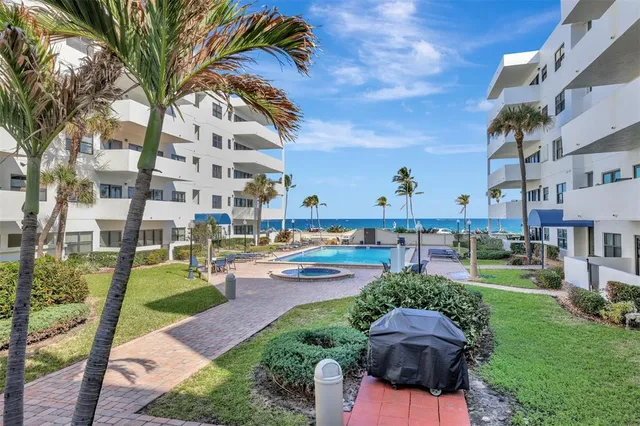a view of a dining room with furniture a kitchen and chandelier