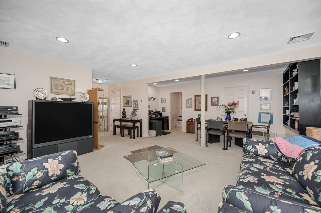 49 Susan Drive Saugus, MA 01906 - Photo 24 of 33 a living room with furniture a dining table and a flat screen tv