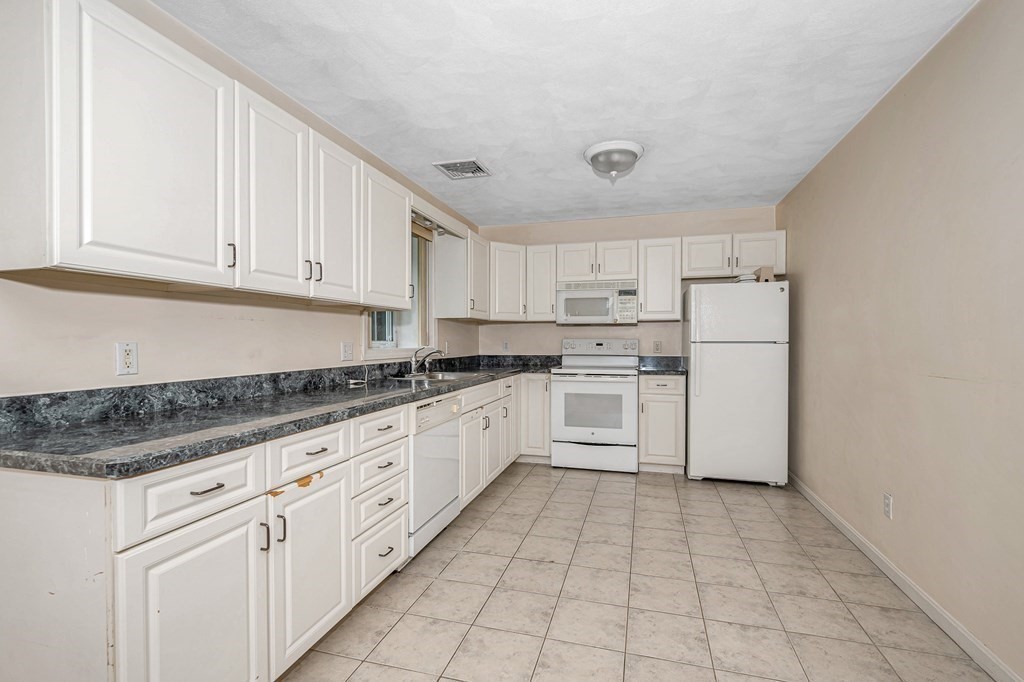 49 Susan Drive Saugus, MA 01906 - Photo 25 of 33 a kitchen with granite countertop white cabinets and white appliances
