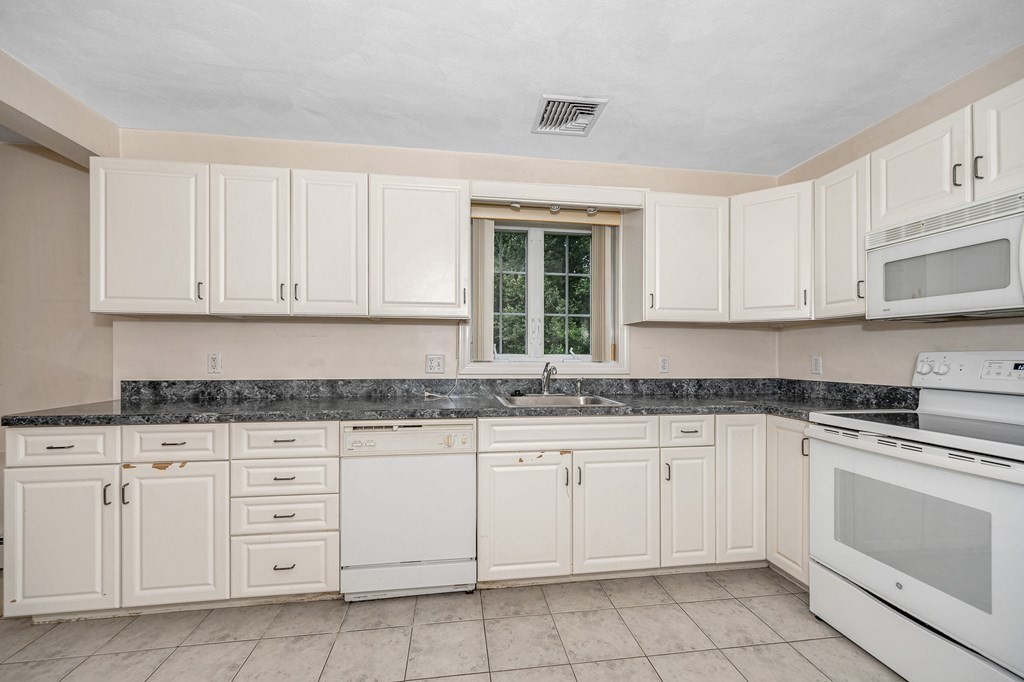49 Susan Drive Saugus, MA 01906 - Photo 26 of 33 a kitchen with granite countertop white cabinets white stainless steel appliances