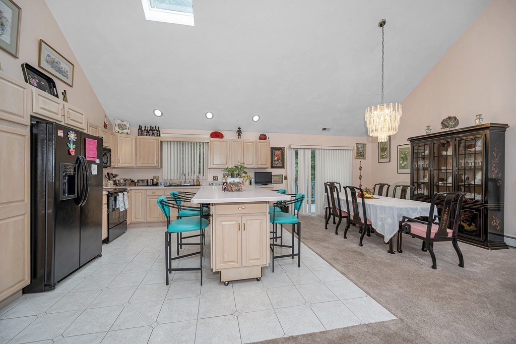 49 Susan Drive Saugus, MA 01906 - Photo 6 of 33 a kitchen with stainless steel appliances kitchen island granite countertop a table chairs and a refrigerator